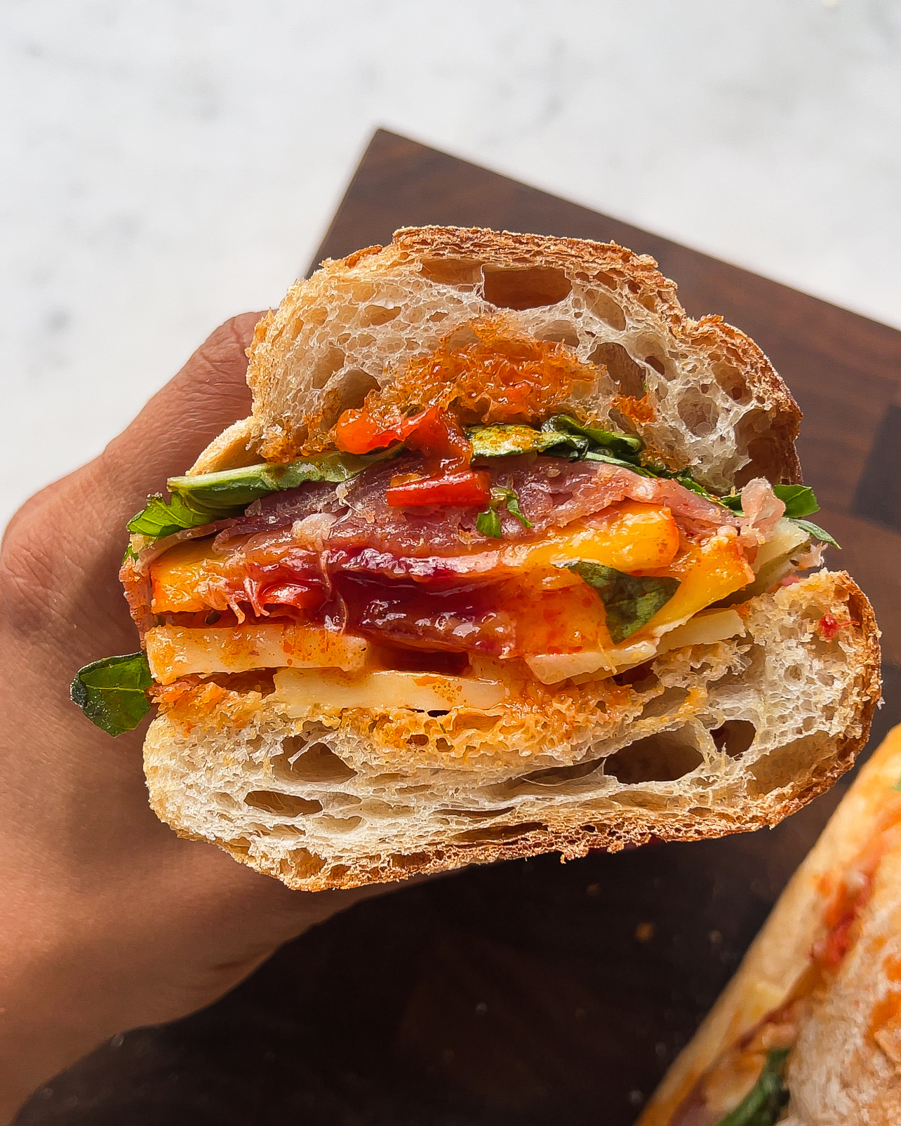 Sweet peaches, salty prosciutto & sharp cheddar layered on toasted bread with Calabrian chilli dressing. The ultimate summer sandwich.